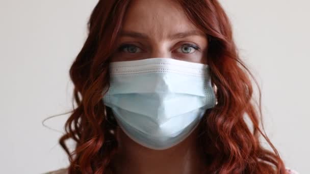 医療用マスクの幸せなアメリカの美しい女性の閉じると、カメラを見て。隔離されたきれいな若い女性, covid-19の概念 — ストック動画