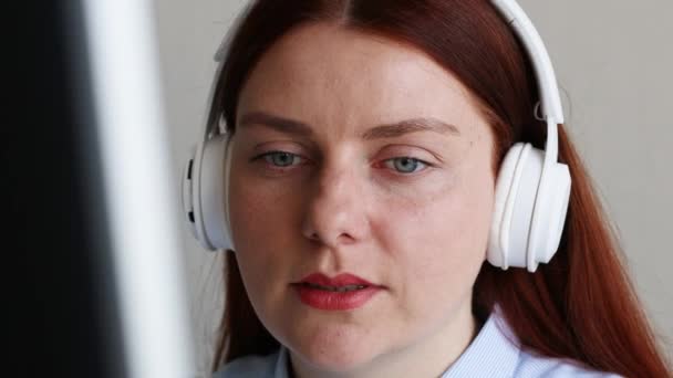 Hermosa mujer en los auriculares que tienen conversación en el chat de vídeo, mientras que el uso de la computadora en casa. Ventajas tecnológicas modernas — Vídeos de Stock