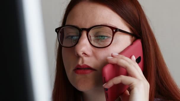 Красива білоруська бізнес-леді розмовляє на смартфоні на роботі — стокове відео