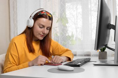 Mesafe öğrenme, eğitim ve çalışma. Evdeki not defterine el ele tutuşma, hedefler, planlar yazma, masa başında iş ve istek listesi yapma,.