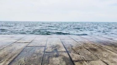 Kıyıya vuran güzel deniz dalgalarıyla ahşap döşeme döşemesi
