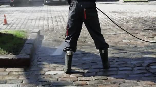 Arbeiter reinigen Auffahrt mit Benzin-Hochdruckreiniger, der den Schmutz spritzt. Hochdruckreinigung. — Stockvideo