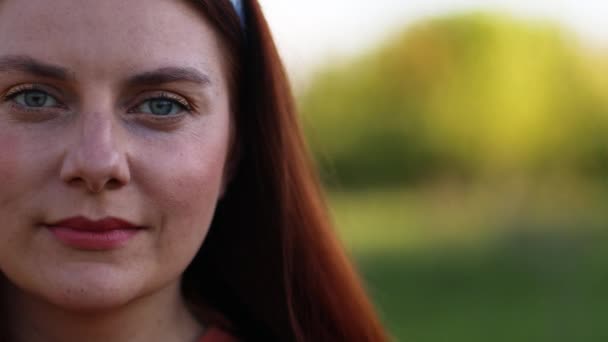 Az emberek szabadsága. Gyönyörű fiatal kaukázusi lány vörös haj repül a szél nézi a kamerát — Stock videók