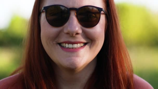 Hermosa modelo de mujer en gafas de sol de moda sonriendo a la cámara. — Vídeos de Stock