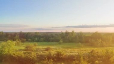 Town train road trip side window with a beautiful landscape. Nature green hills and forest before sunset. Travel from the train.