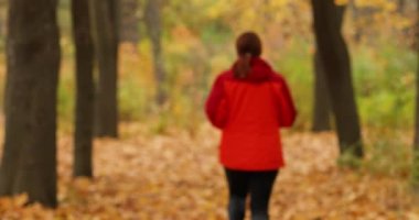 Attractive woman athlete wearing stylish red sport clothing and grey sneakers. Sports and healthy lifestyle concept.