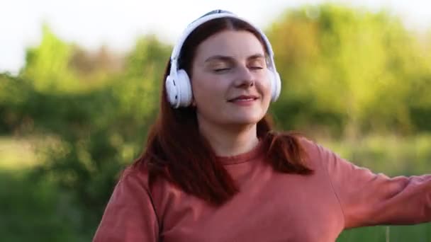 Gelukkig grappig vrouw dansen in de straat luisteren muziek met hoofdtelefoon — Stockvideo