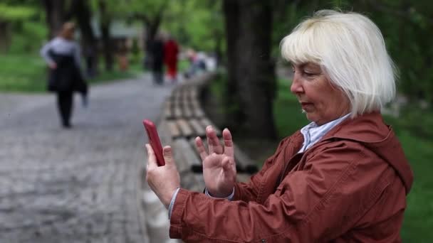 Portraits of woman student using smartphone video conference calling social distance outdoors at the city park — Stock videók