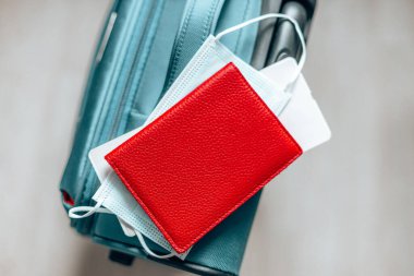 Corona virüs koruyucu yüz maskesi, pasaport, bilet ve bavul covid-19 salgını sırasında seyahat için..
