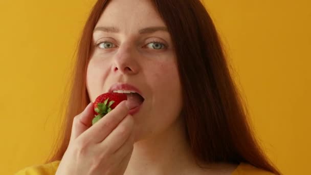 Joyeux jeune femme dégustation de fraises en été, profiter d'une collation bio fraîche, une alimentation saine et concept de mode de vie — Video