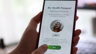 Aşılanmış kadın eli seyahat için cep telefonundaki aşı sertifikası için dokunulmazlık pasaport uygulaması kullanıyor.