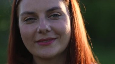 Güzel bir kadın sokakta kameraya gülümsüyor..