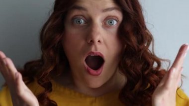 Mutlu, şaşkın kadın avuçları kameradaki gülümsemelere hayretle bakar.