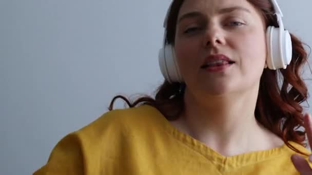 Szczęśliwa kobieta słuchać muzyki w słuchawkach, uśmiech i taniec na białym tle — Wideo stockowe