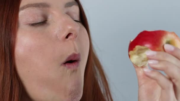 Mujer joven caucásica comiendo manzana roja madura, disfrutando de bocadillos orgánicos frescos, alimentación saludable y concepto de estilo de vida — Vídeo de stock