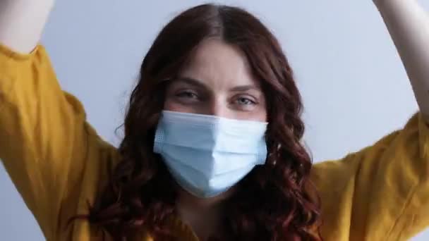 Donna positiva in maschera medica protettiva ascoltare musica, godendo a casa all'interno. — Video Stock