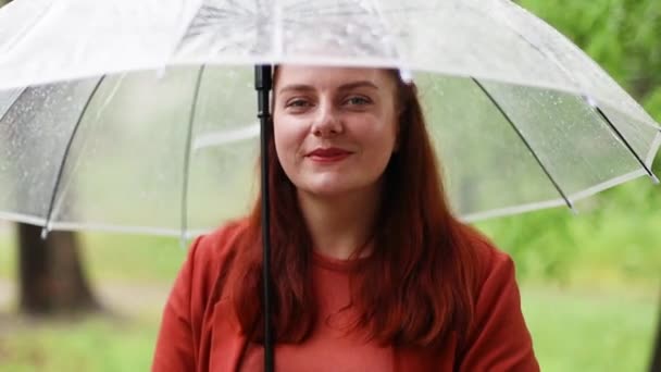 Gyönyörű nő kezében átlátszó esernyő áll odakint esőben nap. Esőcsepp — Stock videók