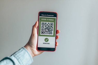 COVID-19. Akıllı telefon ekranında dijital yeşil sertifikalar.
