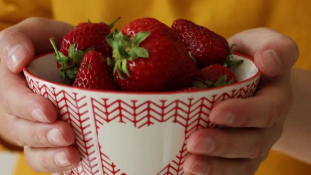 Young woman holding a bowl of fresh red strawberries. Healthy eating and lifestyle concept — Stock Video