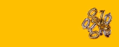 Sarı zemin üzerinde altın ve gümüş 0 ve 1 numara folyo balonlar