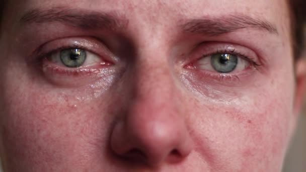 De vrouw huilt. Verontrust depressief meisje met kleurrijke ogen en tranen op de wangen alleen thuis. Tranen stromen.. — Stockvideo