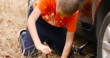 Podolsk, Ukraine: October 25, 2020 Close up of car tire change, hands on wrench closing screws after changing flat tire
