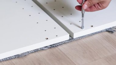 Assembly furniture using screwdriver at home. Furniture assembly concept of tool and white wood