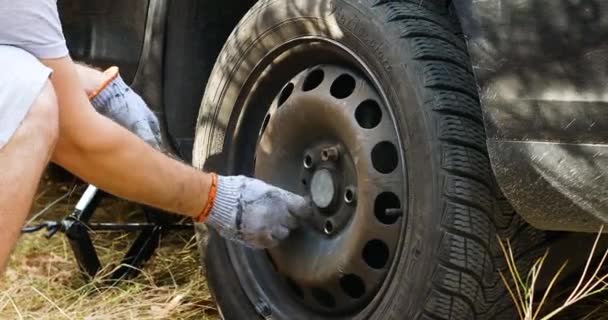 Подольськ, Україна: 25 жовтня 2020 Людина змінює шину на своїй машині в лісі. Погода осінь. Службовець затягує горіхи на шині. — стокове відео