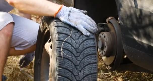 Traveler Man changing flat tire on the road. Replacing the tires on the car — Vídeo de Stock