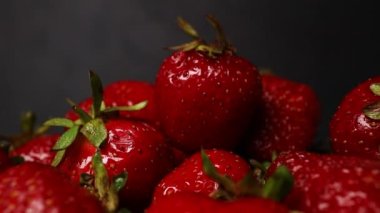 Taze organik kırmızı olgun çilek meyveleri koyu bir arka planda, yakın plan