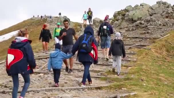 Kasprowy Top, Poland - february 17, 2021: A crowd of tourist hikers climbs the mountain. Travel and Vacation. — Stock video