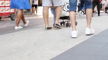 Low angle view of legs and feet of people. Crowd of people walking in pedestrian zone
