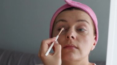 Young woman wearing make up holding makeup brush