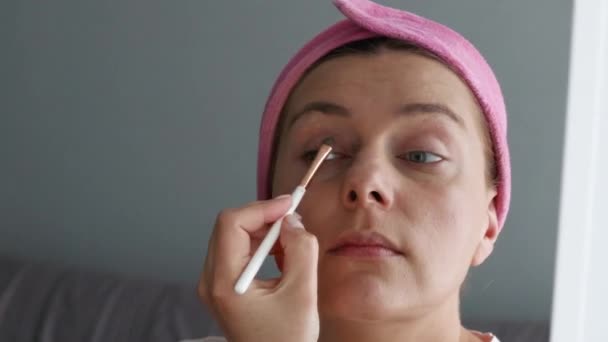 Young woman wearing make up holding makeup brush — Stock video