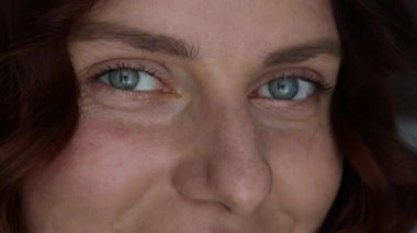 Close up of a smiling young woman model with curly hair smiling for the camera