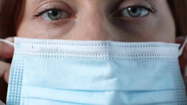 ほこりや感染ウイルスを防ぐために医療用マスクを身に着けている顔の女性を閉じます. — ストック動画
