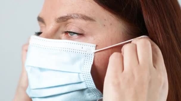 얼굴에 의료용 마스크를 쓰고 있는 캅카스 여성의 얼굴을 클로즈업 한, 의료 용 코로나 바이러스는 19 개의 전염병 예방을 공고히 했다. — 비디오