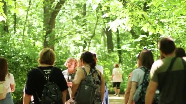 Askania Nova, Ukraine, June, 16, 2021: A group of tourists with a guide walk through the Askania reserve listening to a lecture on plants and rare species of trees — стоковое видео