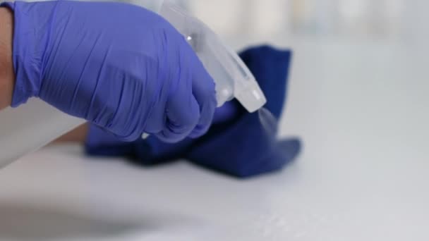 Person disinfecting a table with disinfectant for wiping the table surface at home office against the spread of the corona virus COVID-19. — Stock Video