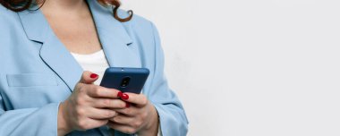 Gri arkaplanda boş ekran fotokopi alanı olan akıllı telefonu tutan kadınların kırpılmış görüntüleri.