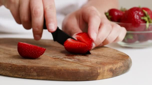 La hembra corta la fresa madura en una tabla de madera en la cocina. Alimento saludable — Vídeos de Stock