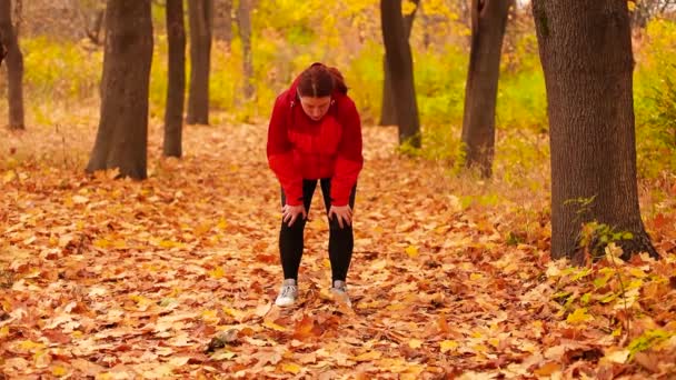 Müde Läuferin wischt sich nach Training im Park den Schweiß ab — Stockvideo
