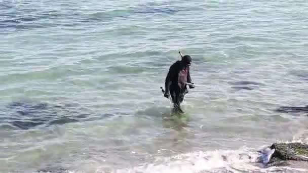 Chasseur sous-marin sur la plage se préparant à plonger dans une mer ou un océan. — Video