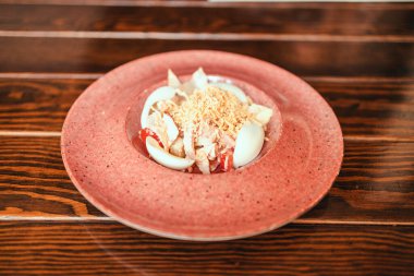 Taze salatayı yumurta ve peynirle birlikte bir restorandaki ahşap bir masada güzel bir tabakta kapat. Geleneksel Amerikan yemekleri