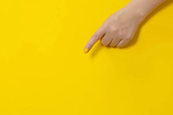 Der Zeigefinger Zeigt Auf Etwas Auf Gelbem Hintergrund Nahaufnahme Handgesten — Stockfoto