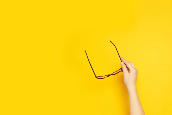 Mano Persona Sostiene Las Gafas Para Visión Sobre Fondo Amarillo — Foto de Stock