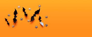 Cadılar Bayramı düz konum siyah kağıt yarasalar uçar ve turuncu arka planda altın yıldızlar, üst görünüm.