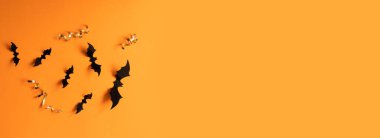 Turuncu arka planda siyah yarasalı Cadılar Bayramı afişi, üst manzara. Poster, fiş, teklif, kupon, tatil indirimi.