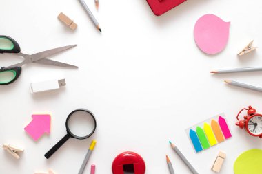 Okula geri dön. Beyaz bir arka plan ve fotokopi alanı üzerine eğitim için renkli okul malzemeleri. Düz üst görünüm