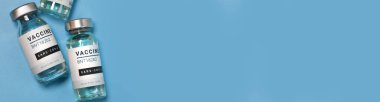 Coronavirus covid-19 deneysel aşı şişeleri laboratuarda kopyalanmış mavi bir plaka üzerinde. Aşılama ve aşılama kavramı